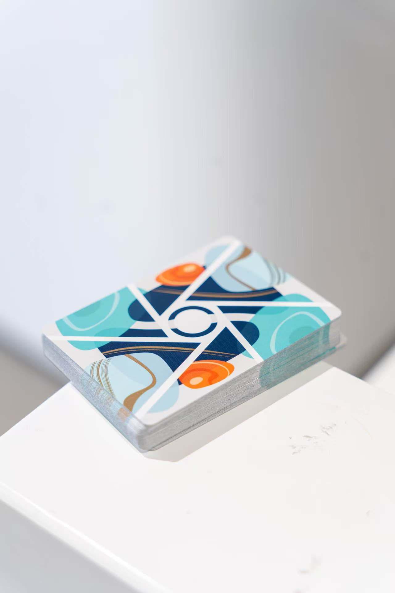 Stack of Virtuoso Moments Nanjing playing cards with a geometric design on a white surface