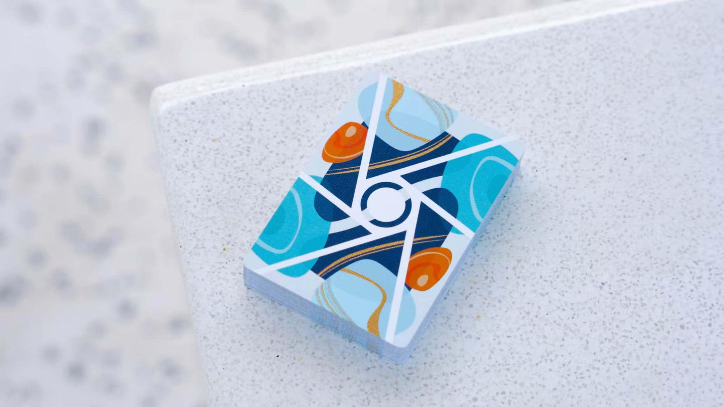 Stack of Virtuoso Moments Nanjing playing cards with a geometric design on a white surface